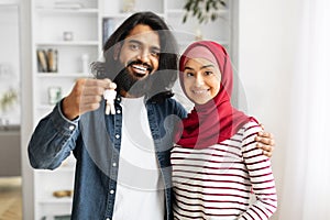 New Home Concept. Happy muslim couple holding house keys