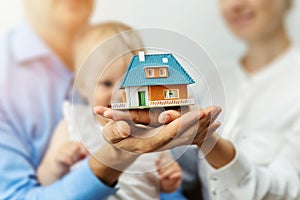 New home concept - young family with dream house scale model photo