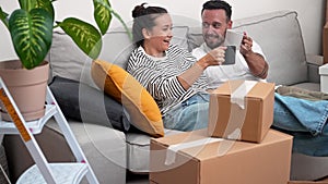 In new home, couple raise coffee cups amid unpacked boxes, unboxing exciting journey into new life