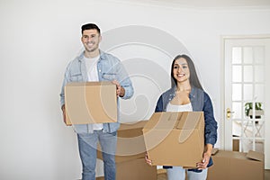 New Home. Happy Young Couple Holding Cardboard Boxes With Belongings