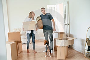 New home to live. Young couple with dog are moving to appartment