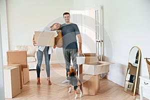 New home to live. Young couple with dog are moving to appartment