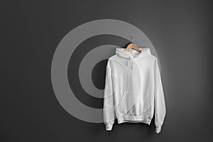 New hoodie sweater with hanger on grey wall