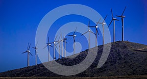 New Horizons. Renewable energy, wind mills on a hill.