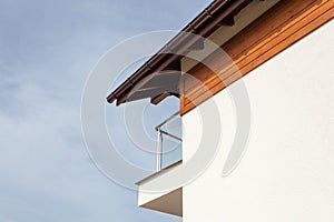 New house with brown rain gutter, white wall and balcony.