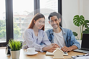 New house / home moving and relocation concept. Happy asian couple signing contract to buy apartment