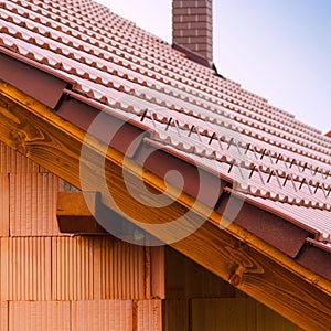 New house with orange brick wall, roof and chimney. House building worker concept.