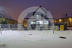 New house with stone fence at snowy night