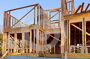 New house under construction framing against a blue sky