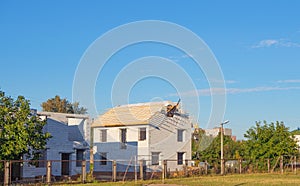 New house under construction with missing windows and unfinished roof. House frame