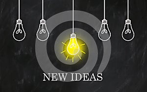 NEW IDEAS phrase with light bulbs on creative chalkboard photo