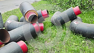 New insulated heating pipes lie on the grass to replace old ones, industry. Thermal engineering