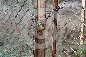 New-ish padlock on old rusty fence gate