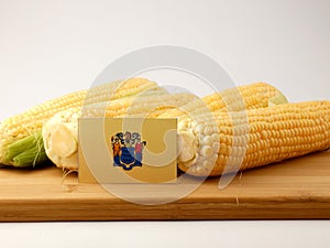 New Jersey flag on a wooden panel with corn isolated on a white