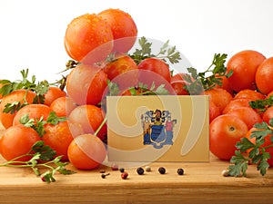 New Jersey flag on a wooden panel with tomatoes isolated on a wh