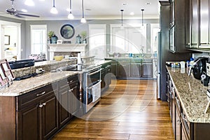A new kitchen with dark wood cabinets, hardwood floors and stainless steel appliances