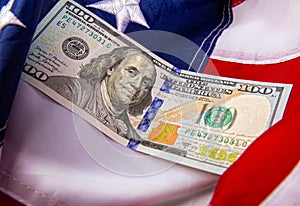 new large hundred dollar bill against the background of the Stars and Stripes United States of America close-up