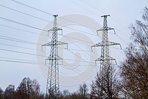 New large mast of an air power line close up, high voltage electricity pylon with thick wires and insulators, blue sky