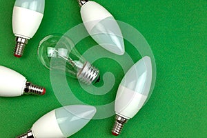 New LED light bulbs and old fluorescent light bulb together, energy saving and eco friendly concept. Green background