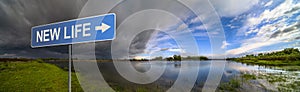 New Life sign on background of amazing landscape nature before thunder storm. Dark clouds cover blue sky at wild river. Incredible