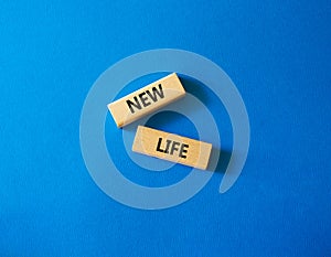 New life symbol. Wooden blocks with words New life. Beautiful blue background. Business and New life concept. Copy space