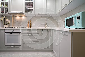 New light grey modern well designed kitchen interior, front view