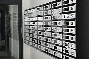 New mailboxes with keyholes, numbers and receipts near entrance in post office