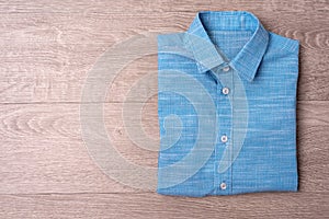 New man shirt blue on wood background.