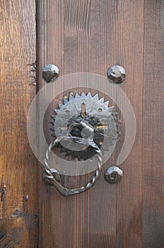 New medieval metal door knocker on wood door close