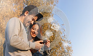 New messages on mobile phone, happy young couple opening inbox to view the pending e-mail communication