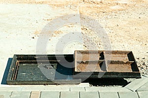 New metal cover over concrete manhole at road construction site close up.