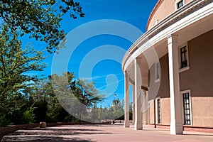 The American flag flies over the Roundhouse or state capitol in historic Santa Fe, New Mexico, USA photo