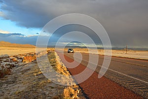 NEW MEXICO, USA - NOVEMBER 22, 2019: car on the road during a red sunset and thunderclouds on the background of the Guadalupe