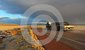 NEW MEXICO, USA - NOVEMBER 22, 2019: car on the road during a red sunset and thunderclouds on the background of the Guadalupe