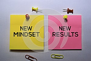 New Mindset - New Results text on sticky notes isolated on office desk