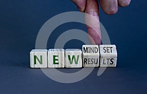 New mindset and results symbol. Businessman turns wooden cubes and changes words `new mindset` to `new results`. Beautiful gre