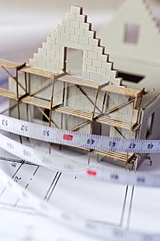 New model house with scaffolding on architecture blueprint plan