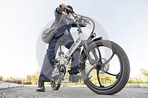 A new modern alternative mode of transport. Eco-friendly electric bike. businessman commuter with electric bicycle