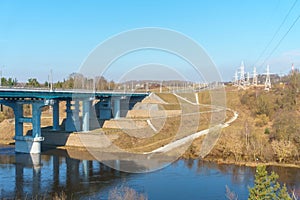 A new modern automobile bridge over the river on the background of the blue sky. A sturdy reinforced concrete bridge, thick