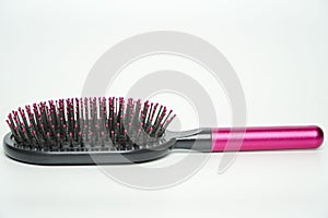 New modern black hairbrush with pink handle isolated on white