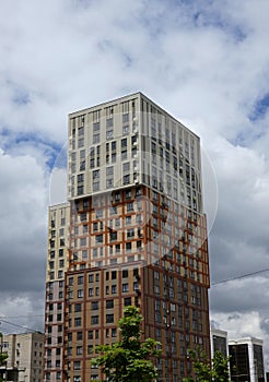 New modern block of flats in green area with blue