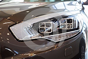 New modern car with elegant quadrate head lamps. Front view