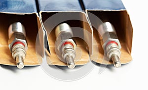 New modern ceramic glow plugs in packaging on a white background. Concept for replacing glow plugs in cold weather