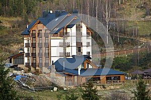 New modern comfortable four-story hotel building with attached premises, attic rooms and high chimneys in ecological rural area on photo