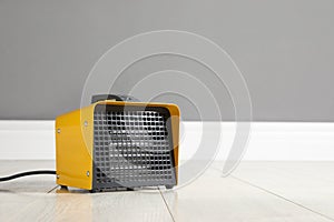 New modern electric heater on floor in room, space for text