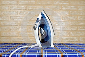 New modern electric steam iron on ironing board