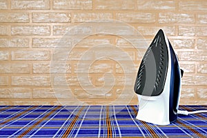 New modern electric steam iron on ironing board