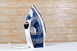 New modern electric steam iron on ironing board