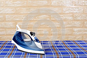 New modern electric steam iron on ironing board