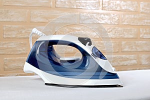 New modern electric steam iron on ironing board
